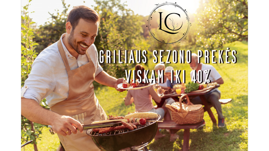 Griliaus įrankių rinkinys ant medinio stalo su prieskoniais