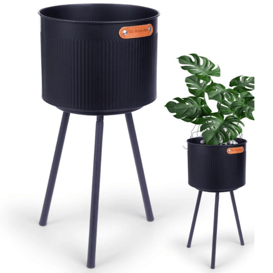 Apvalus juodos spalvos metalinis vazonas su trimis kojelėmis ir grioveliais priekyje